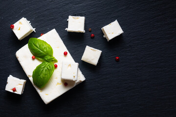 Food concept Organic Feta Cheese on black slate stone board with copy space