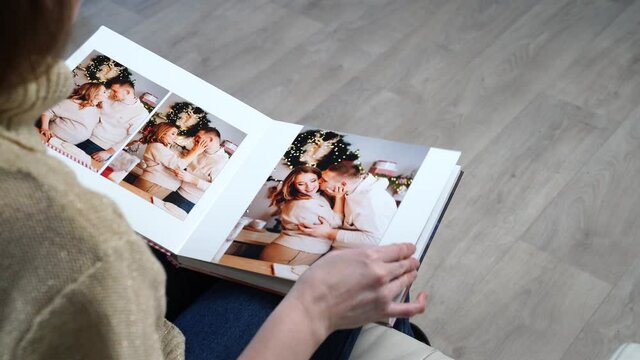 woman flips through the pages of photobook from a new year's family photo shoot