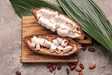 Composition with fresh cocoa fruit and leaves on grunge background