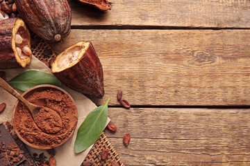 Fresh cocoa fruits and powder on wooden background