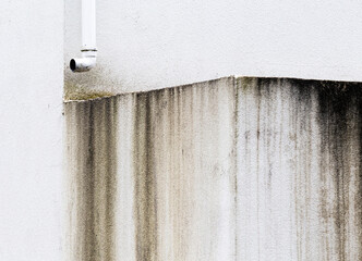 Abstract grungy details of an weathered white street building.