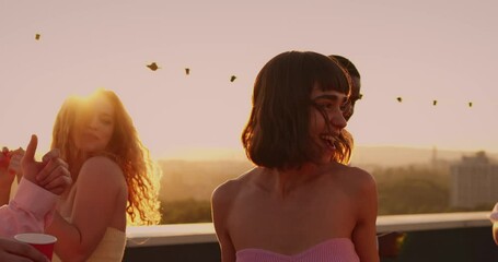 Diverse young people students enjoying summer vacation, partying outdoors together, dancing happily at rooftop. Friendship and youth concept.