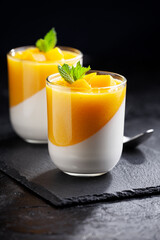 Glass of homemade panna cotta with mango sauce
