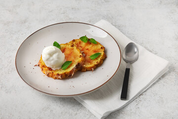 Plate with grilled pineapple slices and ice cream on light background