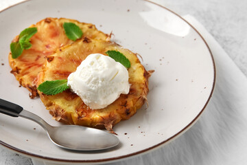 Plate with grilled pineapple slices and ice cream on light background, closeup