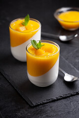 Glass of homemade panna cotta with mango sauce