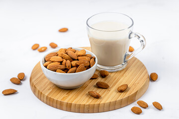 Almond milk in a glass with almond on a wooden table
