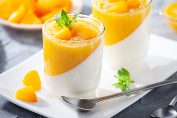 Glass of homemade panna cotta with mango sauce