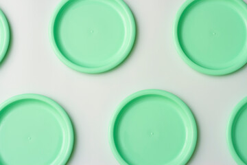 Plastic dishes in mint color on white background