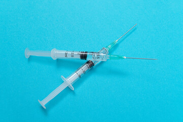 Vaccination, Immunology or Revaccination Concept - Two Medical Syringe Lying on Blue Table in...