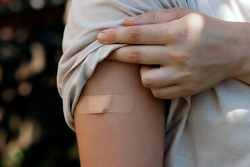 Woman hand with a band-aid on her shoulder