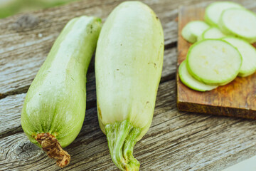 Fresh sliced raw bio zucchini and dill on wooden background. Cooking ingredient