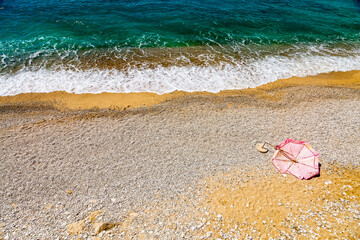 Fototapeta na wymiar Empty beach with broken beach umbrella, nobody on the beach. Beach with no travellers and tourists. Cancellations due to coronavirus covid-19. Quarantine.