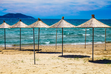 Empty beach with reed beach umbrellas, nobody on the beach. Beautiful blue sky, hot weather. Beach with no travellers and tourists. Cancellations due to coronavirus covid-19. Quarantine.
