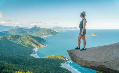 Poster woman on the edge of the abyss. Pedra do Telegrafo is a tourist destination in Rio de Janeiro. © Aliaksei