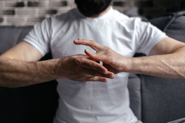 A brutal man sitting in meditation with his hands folded in yoga mudras