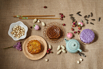 Variety of moon cake on table. Mid autumn festival food and drink. Text translation: Pure Lotus