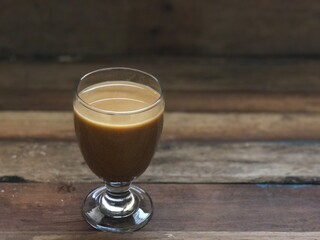 Wine glasses has iced latte coffee on empty old wood table top,dimly light,free space for text design.Concept of Relaxation in Coffee time.