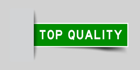 Inserted green color sticker label with word top quality on gray background