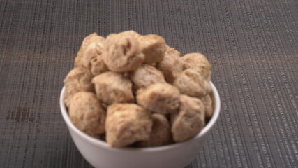 Raw soya chunks on dark background. Healthy, nutritious soybean meat, chunks isolated.Vegan food concept.
