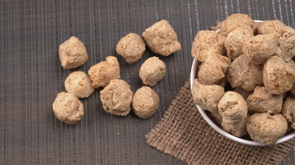 Raw soya chunks on dark background. Healthy, nutritious soybean meat, chunks isolated.Vegan food concept.