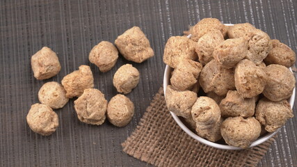 Raw soya chunks on dark background. Healthy, nutritious soybean meat, chunks isolated.Vegan food concept.