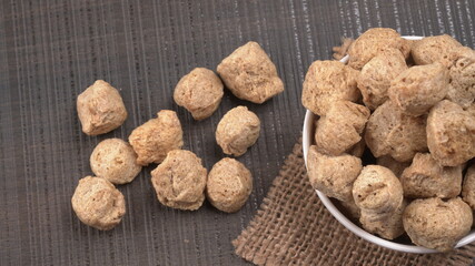 Raw soya chunks on dark background. Healthy, nutritious soybean meat, chunks isolated.Vegan food concept.