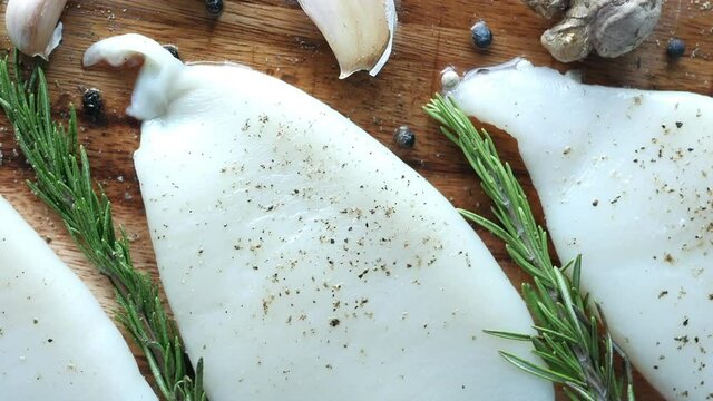 Fresh boneless skinless cod filet on chopping board 