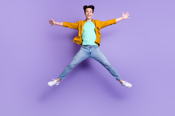 Fototapeta na wymiar Full body photo of young man happy positive smile have fun jump up isolated over violet color background