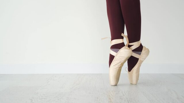 Ballerina legs in beige pointe shoes in studio