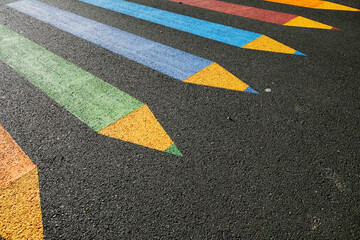 Colorful craons design painted as a zebra crossing in front of a school.