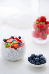 Healthy Chia Pudding with Coconut Milk, strawberries, chia seeds, blueberries in a Glass. Concept of healthy eating, healthy lifestyle, dieting, fitness menu. 