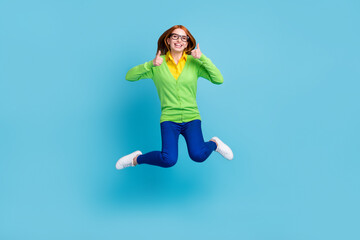 Fototapeta na wymiar Full length body size view of nice pretty cheerful girl jumping showing thumbup isolated over bright blue color background