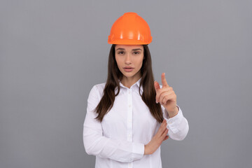 serious woman boss in protective helmet and white shirt pointing finger on camera, female boss
