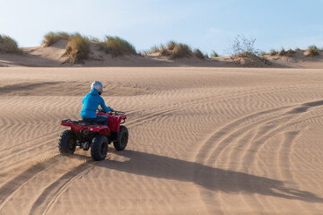 Scenic view of a person driving a red Quad Bike at the beach in Essaouira, Morocco
