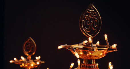 Diwali candles with om symbol on a dark background - obrazy, fototapety, plakaty