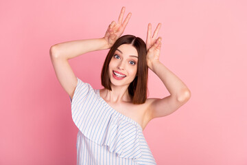 Photo of young excited girl happy positive show fingers peace cool v-sign ears isolated over pink color background