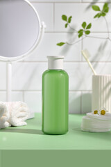 Fototapeta na wymiar Balancing skin bottle green with white cotton towel in the bathroom. 
