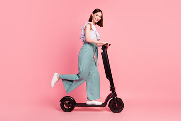 Full size profile side photo of young girl happy positive smile driver trip weekend scooter isolated over pink color background © deagreez