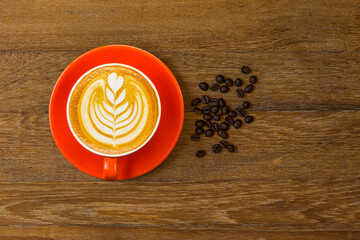Latte coffee in red cup decorated with coffee beans