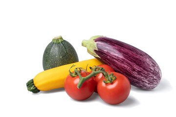 Two variations of zuchinni, tomatoes and an eggplant - ingredients for ratatouille - on a pile seen from under