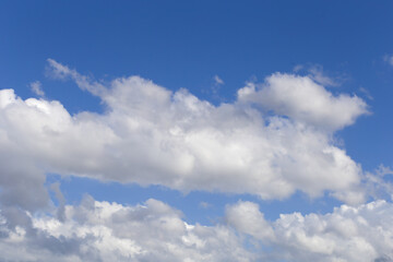 Naklejka na ściany i meble Background of white summer clouds on blue sky.