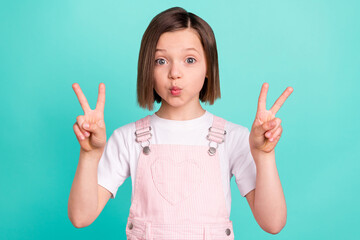 Photo of funny happy cheerful young girl send air kiss make v-signs isolated on pastel teal color background