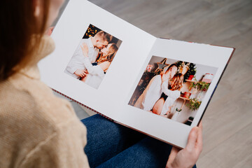 woman watches photobook from photo shoot of married couple during pregnancy.