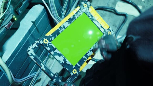 A cyberman in his high tech lab works on his tablet with green screen. Animation for futuristic, fiction, cyber and sci-fi backgrounds. A view of a cyborg in his laboratory of the future.