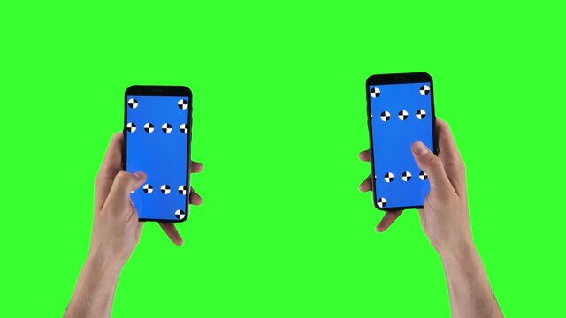 Two male hands with smartphones swipe left and right on touchscreens on alpha channel. Man slides pages on mobiles with tracking marker. Double cellphones on green screen. Gadgets on mockup background