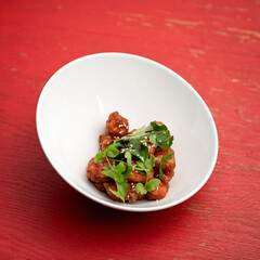 Wok meal, Stir-fried Oriental dinner on white plate or bowl isolated on pink background. Pan-asian cuisine, spicy food.