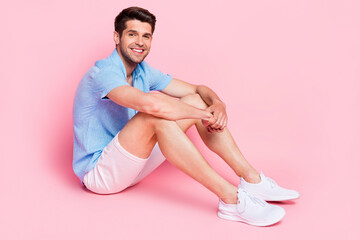 Photo of tourist boyfriend guy sit floor wait wear blue shirt shorts footwear isolated on pink color background
