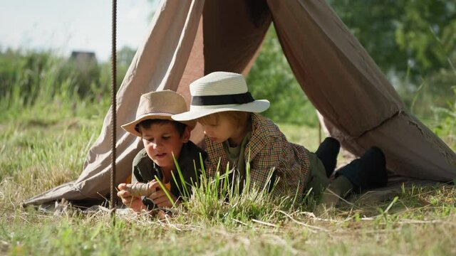summer holiday in countryside, cute boys in straw hats have fun on vacation in green meadow in bigwam