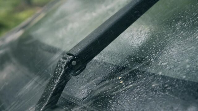 Spraying car windshield washer fluid slow motion, working wipers 